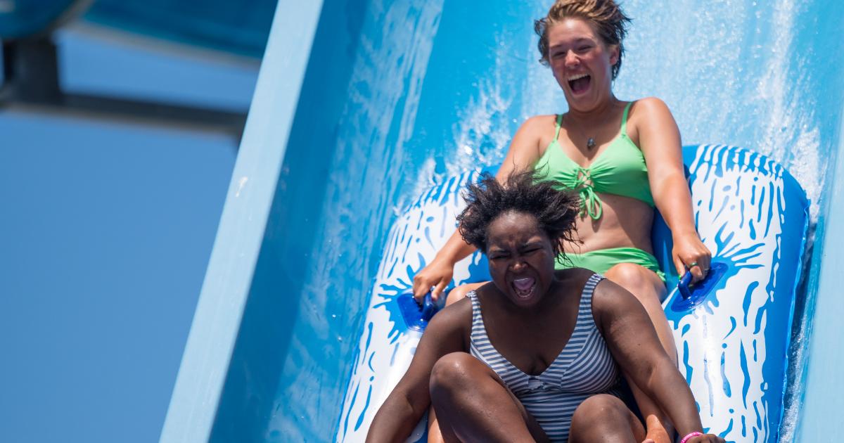 Woman in striped bath suit and girl in green suit