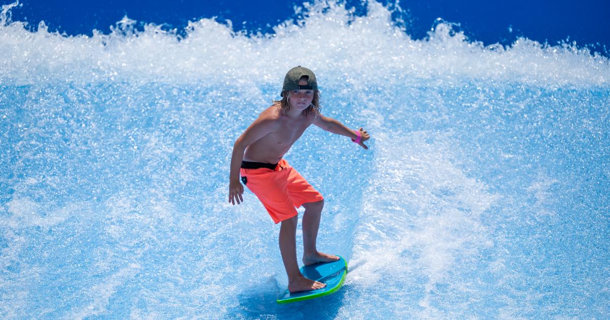 Boy with hat and orange shorts standing up