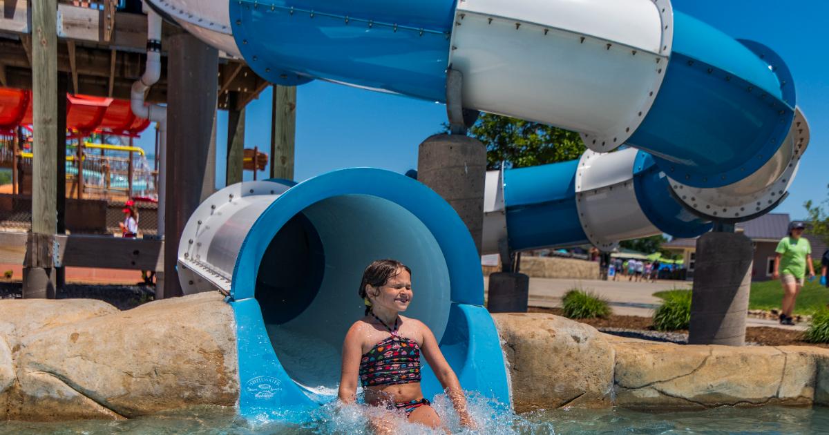 Girl coming out of blue and white slide