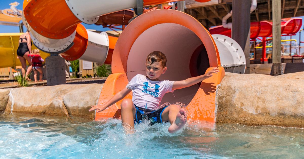 Boy in white coming out of slide