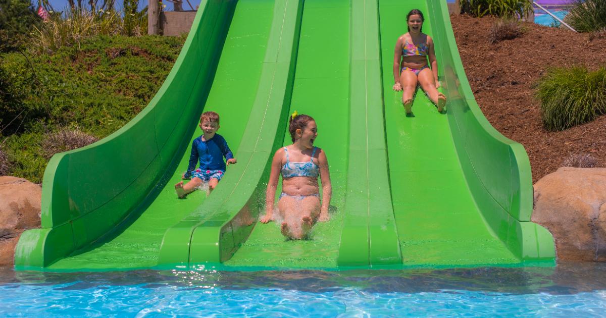 boy, young girl and young girl on green slide
