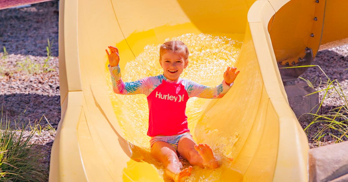 Girl with pink rash card on yellow slide