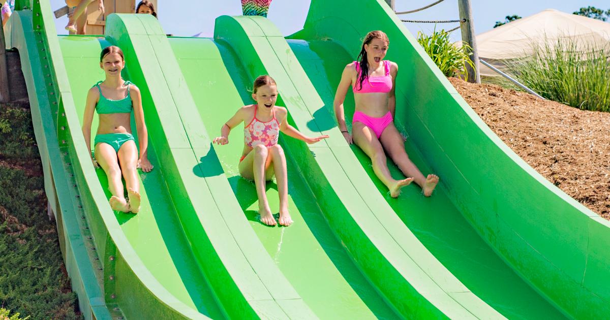 3 girls on green slides